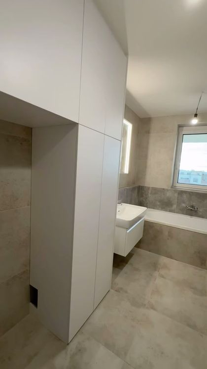 Realizace nábytku do nového domu v Pražských Štěrboholích. Prostor připraven pro pračku se sušičkou a led osvětlená zrcadlová skřínka.