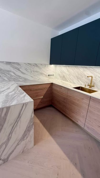 V této minimalistické kuchyni jsou zajímavé materiály jako například Fénix což je povrchová úprava která odolává otiskům prstů a je tak neustále dokonale matná.